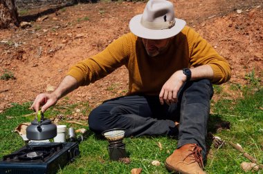 Gezgin adam tarlada kahve yapıyor.