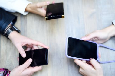 Masada telefonu olan üç kadının elleri.