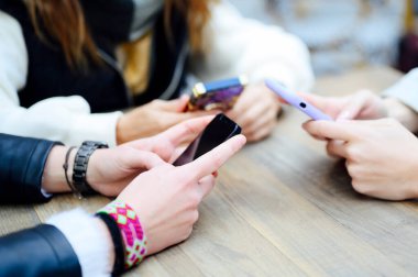 Akıllı telefonlu üç kadının ellerini kapat.