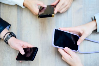 Yukarıdan cep telefonlu eller.