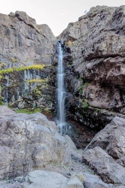 Fas 'ın Atlas Dağları' nın göbeğindeki engebeli uçurumlardan nefes kesici bir şelale düşüyor. Huzurlu ve güçlü sahne, doğanın ham güzelliğini yakalar. Sisin içinden süzülen güneş ışığı büyüleyici ve huzur verici bir atmosfer yaratır.