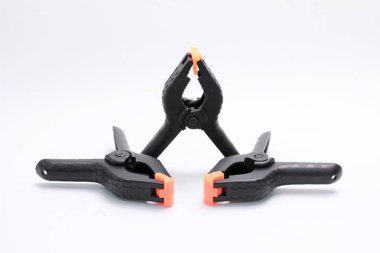 Beyaz arkaplanda izole edilmiş siyah plastik yay kıskaçları.