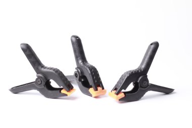 Beyaz arka planda izole edilmiş siyah plastik yay kıskaçları. Minimalist araç kavramı.