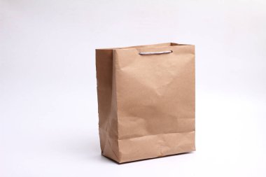 beyaz zemin üzerinde kahverengi kağıt torba.