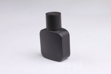 Beyaz arka planda izole edilmiş siyah parfüm şişesi.