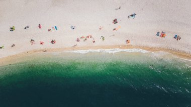 Üst manzara, deniz tarafından yıkanmış güzel bir sahilde dinlenen bazı insanların muhteşem hava manzarası. Bisceglie (Apulia, İtalya)
