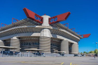 Milano 'daki San Siro Stadyumu (Giuseppe Meazza), İtalya' nın Lombardy kentinin mimari bir ikonu olan mavi gökyüzü altında sarmal sütunlar ve kırmızı geçitlerle