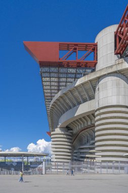 Milano 'daki San Siro Stadyumu (Giuseppe Meazza), İtalya' nın Lombardy kentinin mimari bir ikonu olan mavi gökyüzü altında sarmal sütunlar ve kırmızı geçitlerle