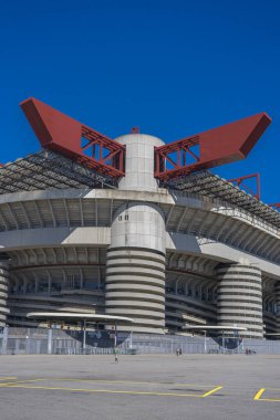 Milano 'daki San Siro Stadyumu (Giuseppe Meazza), İtalya' nın Lombardy kentinin mimari bir ikonu olan mavi gökyüzü altında sarmal sütunlar ve kırmızı geçitlerle