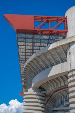 Milano 'daki San Siro Stadyumu (Giuseppe Meazza), İtalya' nın Lombardy kentinin mimari bir ikonu olan mavi gökyüzü altında sarmal sütunlar ve kırmızı geçitlerle