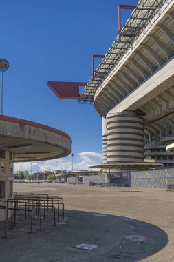 Milano 'daki San Siro Stadyumu (Giuseppe Meazza), İtalya' nın Lombardy kentinin mimari bir ikonu olan mavi gökyüzü altında sarmal sütunlar ve kırmızı geçitlerle