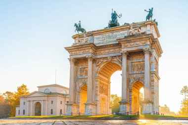 Milano 'daki Arco della Pace. Altın sabah ışığı, mavi sonbahar gökyüzü.