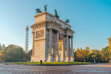 Milano 'daki Arco della Pace. Altın sabah ışığı, mavi sonbahar gökyüzü.