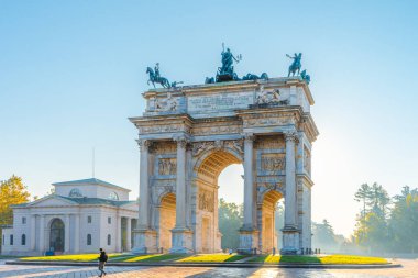 Milano 'daki Arco della Pace. Altın sabah ışığı, mavi sonbahar gökyüzü.