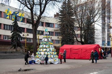 Ivano-Frankivsk, Ukrayna - 15 Aralık 2022. Ülkedeki savaş durumu nedeniyle, geleneksel Noel ağacı yerine Ukrayna temalı çocuk çizimleri olan bir yapı kuruldu. Resimli baskı
