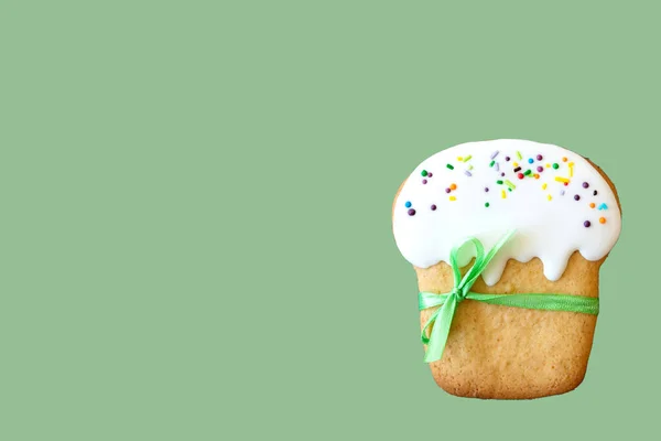 Banner. Easter Paska on a uniform green background. Cookies painted with sweet fondant in the form of traditional Easter bread - Paska. Copy space