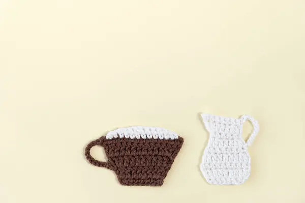 Coffee with milk. A cup of coffee and a jug of milk. All elements are crocheted.