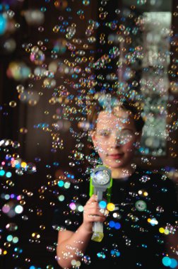 Baloncuk Fırtınası 'ndan Ateş Baloncukları. Uluslararası Çocuk Günü. Arka plandaki bir çocuğun dikkati dağılmış. Baloncuklara odaklan