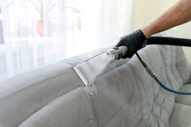 Temizlik konsepti. Odadaki kanepeyi temizliyorum. Virüs önleme içeride dezenfekte ediliyor. Mobilya temizleme işlemi. Profesyonel kimyasal temizlik.