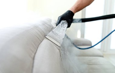 Temizlik konsepti. Odadaki kanepe. Virüs önleme içeride dezenfekte ediliyor. Mobilya temizleme işlemi. Profesyonel kimyasal temizlik.