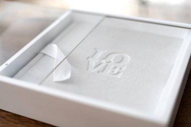 El yapımı hediye kutusu kabartmalı bir aşk tasarımı içeriyor, kırsal bir ahşap masada dinleniyor. Gönüllü anları kutlamak için mükemmel. Bu kutu hediye verme beklentisini arttırıyor..