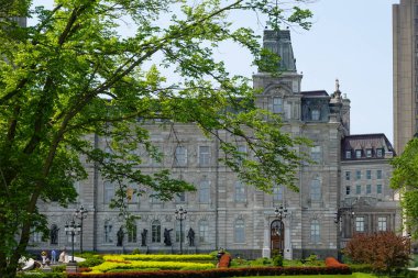 Klasik mimarisi ve saat kulesi olan resmi kurumsal bina. Simetrik tasarımı olan taş cephe tipik sivil veya hükümet yapıları. Ağaçlar tarihi idari binanın dış çerçevesini oluşturuyor.