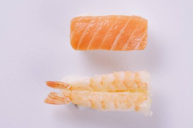 Beyaz tabakta karides nigiri ve somon nigiri..