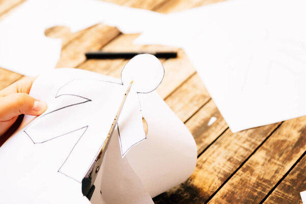 April Fool's Day concept. Child cutting papers with April Fool's Day dolls.