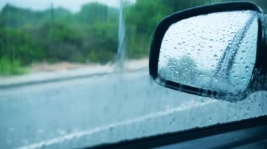 Arabanın içinden yağmuru izleyen biri..