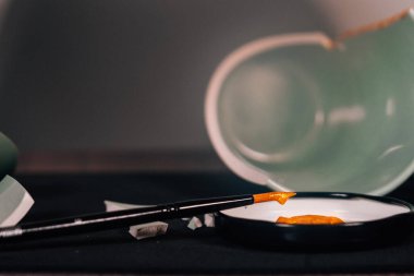 Kintsugi konsepti. Bir kadehi altınla tamir eden kişi..