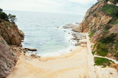 Kayaların üzerinde dalgalar koparken denize giren kayalar..