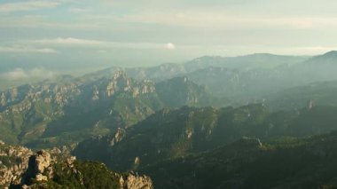 Gün batımında bulutlu dağların panoramik manzarası.
