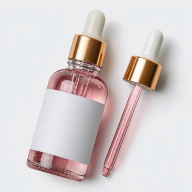 Pembe serum ve beyaz arka planda altın aksanlı zarif cam damlalar.