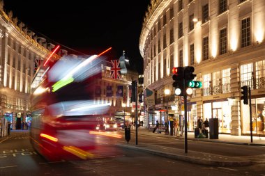 Londra, Birleşik Krallık 6 Ekim 2013: Regent Caddesi 'nde gece hareket halindeki kırmızı çift katlı bir otobüsün bulanık ışık yolları, aydınlık klasik binalar ve şehir trafiği ile uzun pozlu fotoğrafı.
