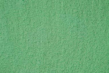 Canlı yeşil bir yüzey, sanatsal projeler veya tasarım çalışmaları için görsel olarak çekici bir zemin oluşturan yumuşak, dokulu bir kaplama içerir. Eşit renk kullanımı çok yönlülüğü arttırır.