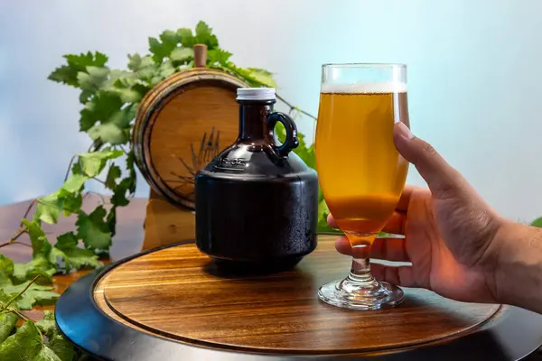 Birayla ahşap bir masanın üzerinde homurdanan bir bira, lale bardağında servis edilen taze zanaatkar birası.