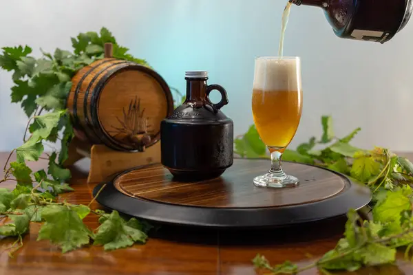 Kırsal bir ahşap tepside yeni dökülmüş sarı bira dolu bir hayat, homurdanan ve meşe fıçısı da dahil olmak üzere demlenen aksesuarlarla tamamlanıyor..