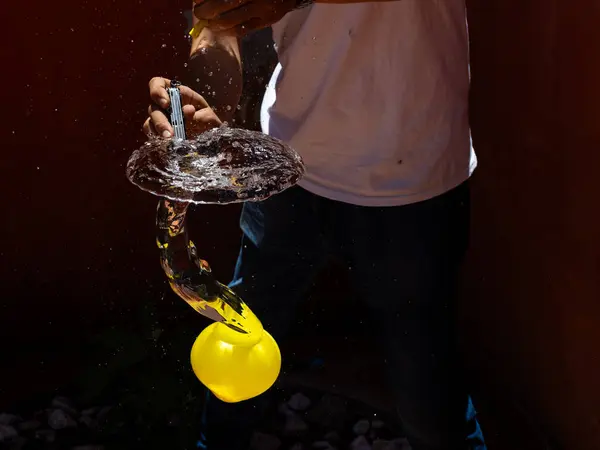 Su sıçratma ve donmuş hareketi gösteren bıçakla patlayan bir su balonunun yüksek hızda yakalanması. Yaz, eğlence, enerji, aksiyon ve ferahlatıcı anlar için mükemmel.