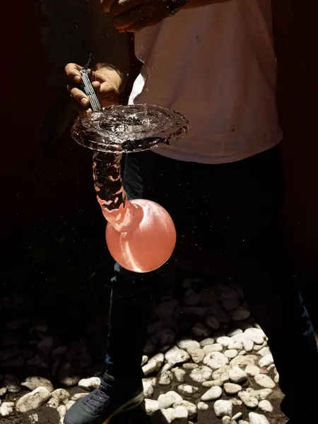 Su sıçratma ve donmuş hareketi gösteren bıçakla patlayan bir su balonunun yüksek hızda yakalanması. Yaz, eğlence, enerji, aksiyon ve ferahlatıcı anlar için mükemmel.