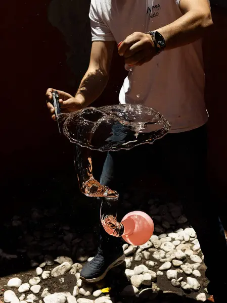 Su sıçratma ve donmuş hareketi gösteren bıçakla patlayan bir su balonunun yüksek hızda yakalanması. Yaz, eğlence, enerji, aksiyon ve ferahlatıcı anlar için mükemmel.