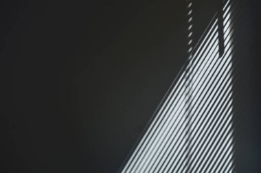 Gri duvardaki perdenin soyut gölge çizgileri. Gri boş duvarda sabah güneşinden gelen güzel pencere gölgesi.. 