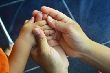 Ebeveynler çocuklarının elini kontrol ediyorlar. Aileyi önemsemek. Aile sağlığı kavramı