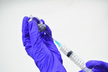 Aşı sıvısını şırıngayla şişeye koymaya hazırlanan bir doktorun eli. Doktor, hemşire, bilim adamı, eldivenli araştırmacı grip, aşı hastalığı insan klinik denemelerine aşı aşısı, ilaç ve ilaç konseptine hazırlanıyor..