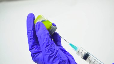 Doktorun elini kapayıp beyaz arka plandaki hastaya aşı için şırınga ve ilaç verin. Şırınga kullanan hemşire gribe karşı korunma için hastaya aşıdır. İlaç tedavisi