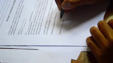 İş sözleşmesi imzalayan bir iş adamı, erkek eli kalem imzasıyla kapatan bir adamın eli sözleşme ya da anlaşma formu imzalamak için bir kalem kullanır. veya garanti belgesi veya kredi başvurusu ve diğer belgeler 