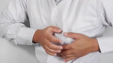 Karın ağrısı, ağrı ve rahatsızlığı olan hasta Asyalı bir adam, şiddetli karın ağrısı, sol böbrek enfeksiyonu ya da apandisit, karnının sol tarafında ağrı, karın bölgesini ağrı ifadesiyle sıkıştıran bir hasta.