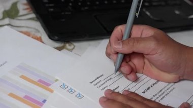 Bir adamın eli sözleşme ya da anlaşma formu imzalamak için kalem kullanır. veya garanti belgesi veya kredi başvurusu ve diğer belgeler 