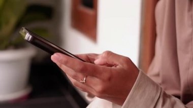 Kadının parmaklarını kapat ve hemen akıllı telefon ekranına yaz. Cep telefonu tutan kadının yan görüntüsü