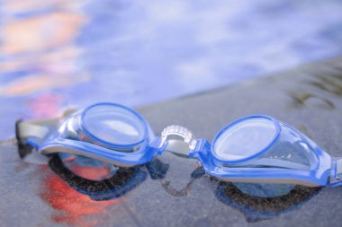 Yüzme gözlükleri temiz bir yüzme havuzunun kenarında.
