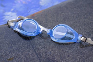 Yüzme gözlükleri temiz bir yüzme havuzunun kenarında.